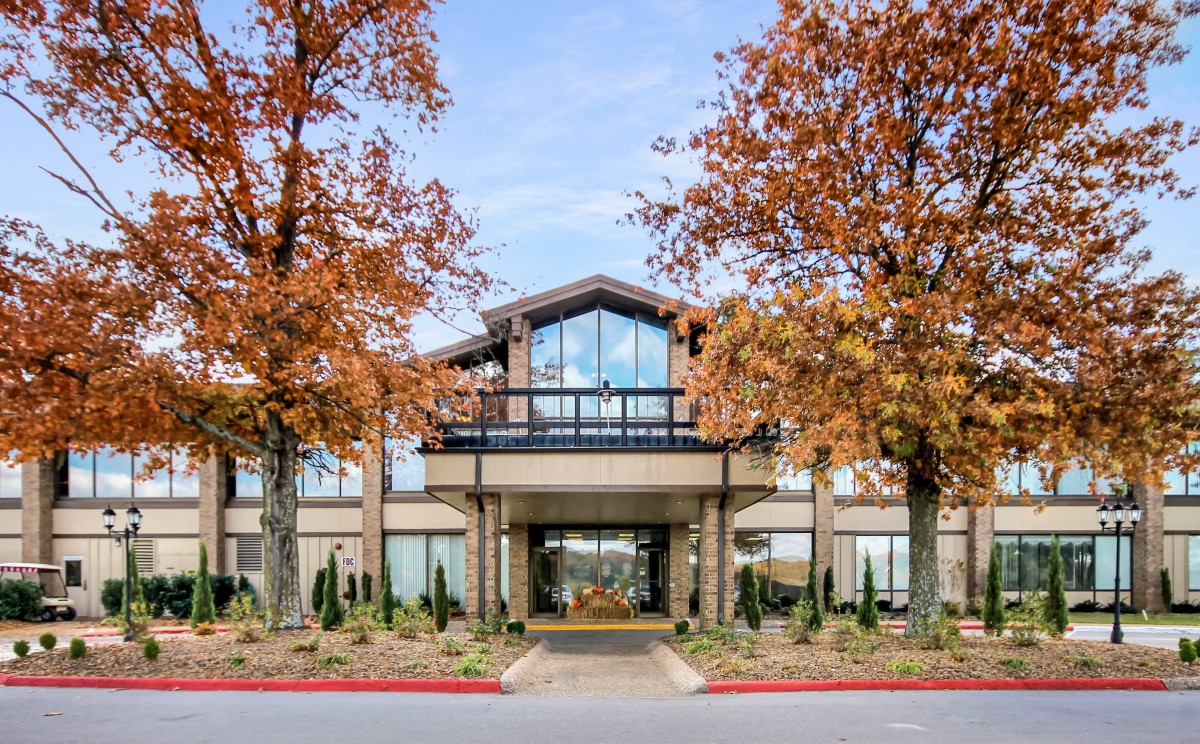A hotel entrance surrounded by autumn trees.