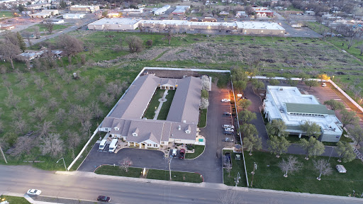 Aerial view of a residential complex with a parking lot, surrounded by greenery.