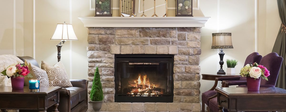 A cozy stone fireplace with a warm fire burning inside, adding charm to the home's interior.