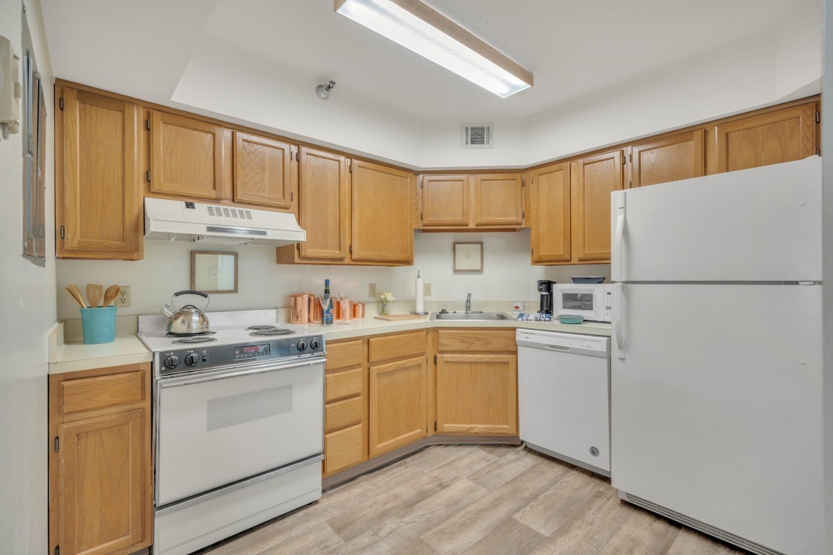 A well-organized kitchen with wooden cabinets and essential appliances.