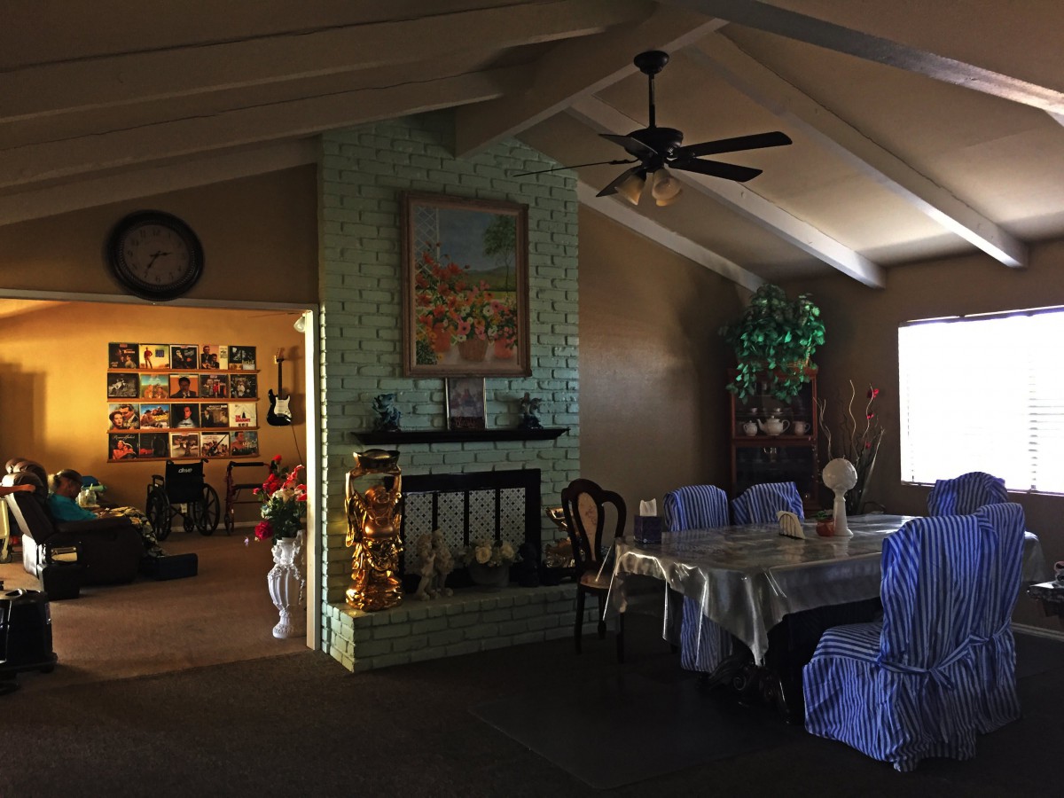 A cozy living and dining area featuring a fireplace, decorated table, and various decorations.