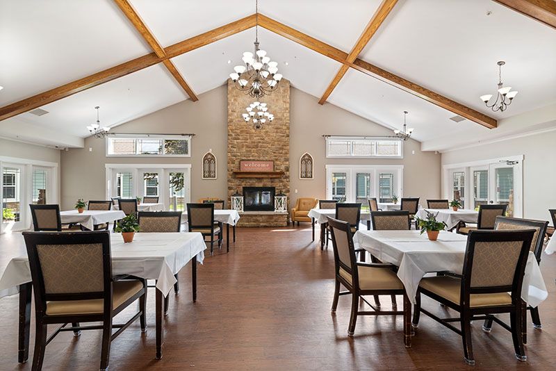Spacious dining room with wooden beams and a central fireplace.