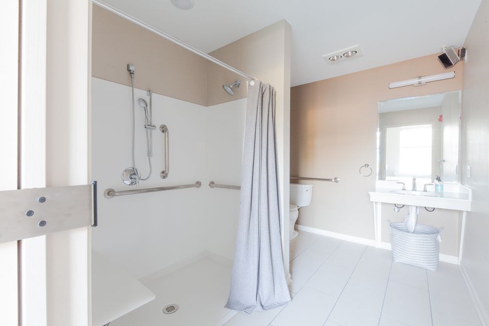 Modern accessible bathroom with a shower and safety grab bars.