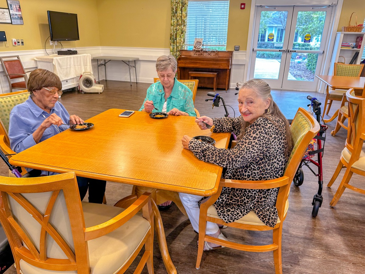 A group of seniors enjoying a conversation around a table indoors.