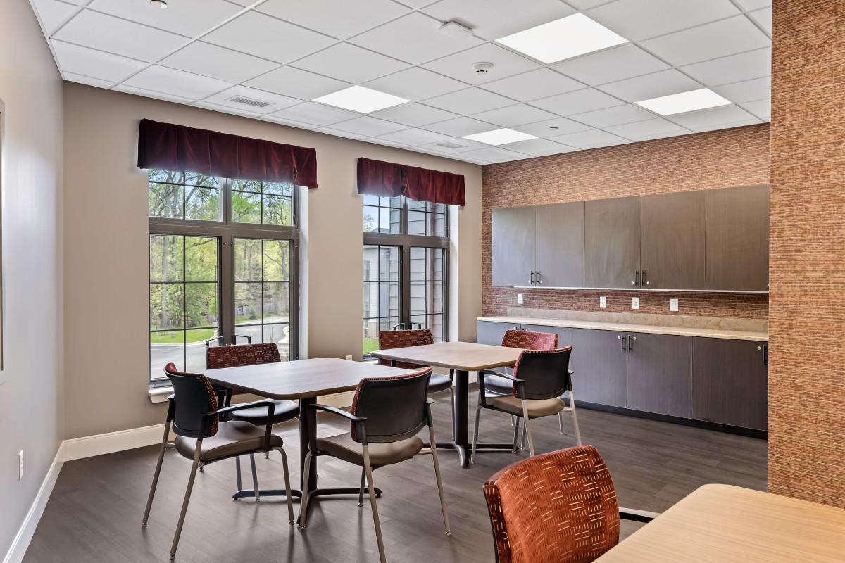A modern dining area with tables, chairs, and ample natural light.