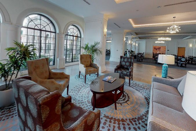 A stylish hotel lobby with elegant armchairs and a central coffee table.