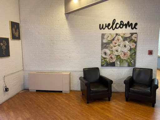 A cozy waiting area featuring comfortable black chairs and a welcoming atmosphere.