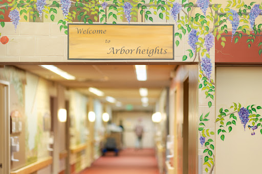A welcoming sign for Arbor Heights, adorned with decorative floral motifs, inviting visitors into the comforting interior space.