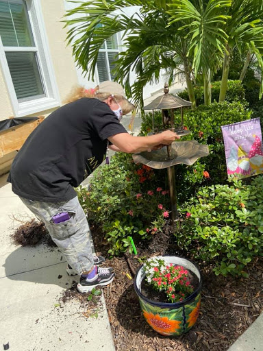 A person tending to a garden, watering plants and enjoying the beauty of nature.