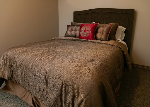 A beautifully made bed with a decorative throw and pillows, inviting a sense of comfort and relaxation.