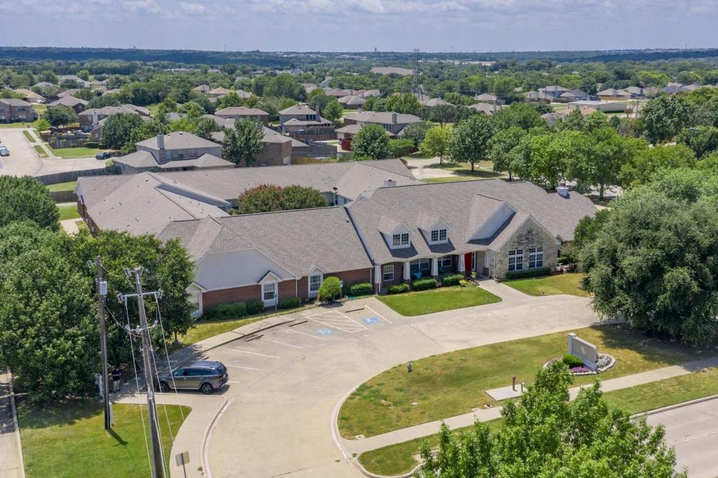 Aerial view of a suburban building with a surrounding residential area and parking lot.