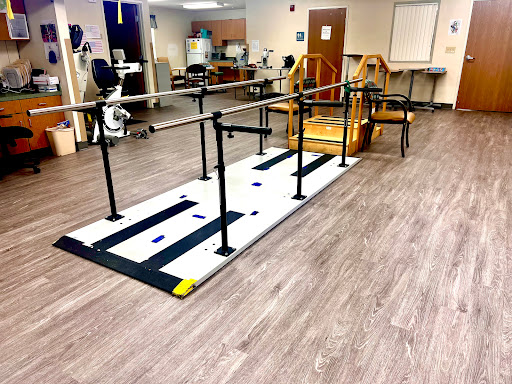 A rehabilitation area featuring a walking pathway with handrails for physical therapy exercises.
