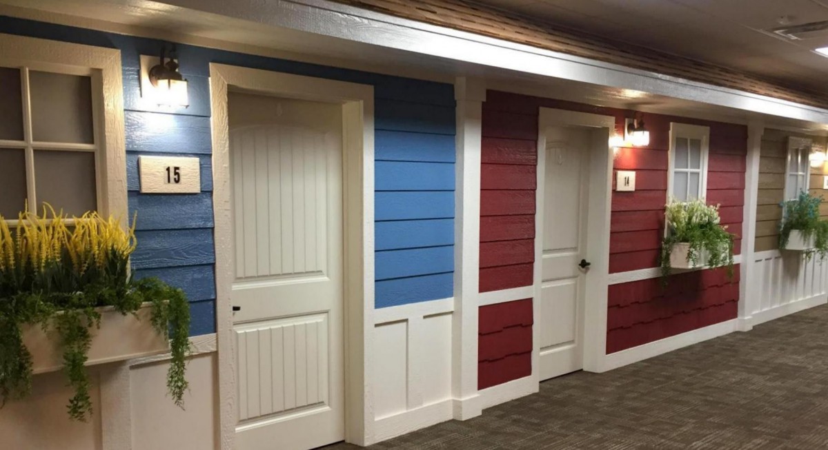 Corridor with blue and red paneled walls and white doors.