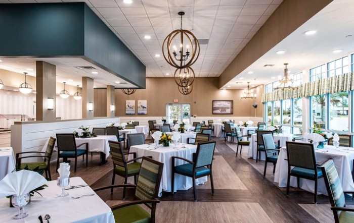 A modern and stylish restaurant interior with neatly arranged tables and elegant chandeliers.