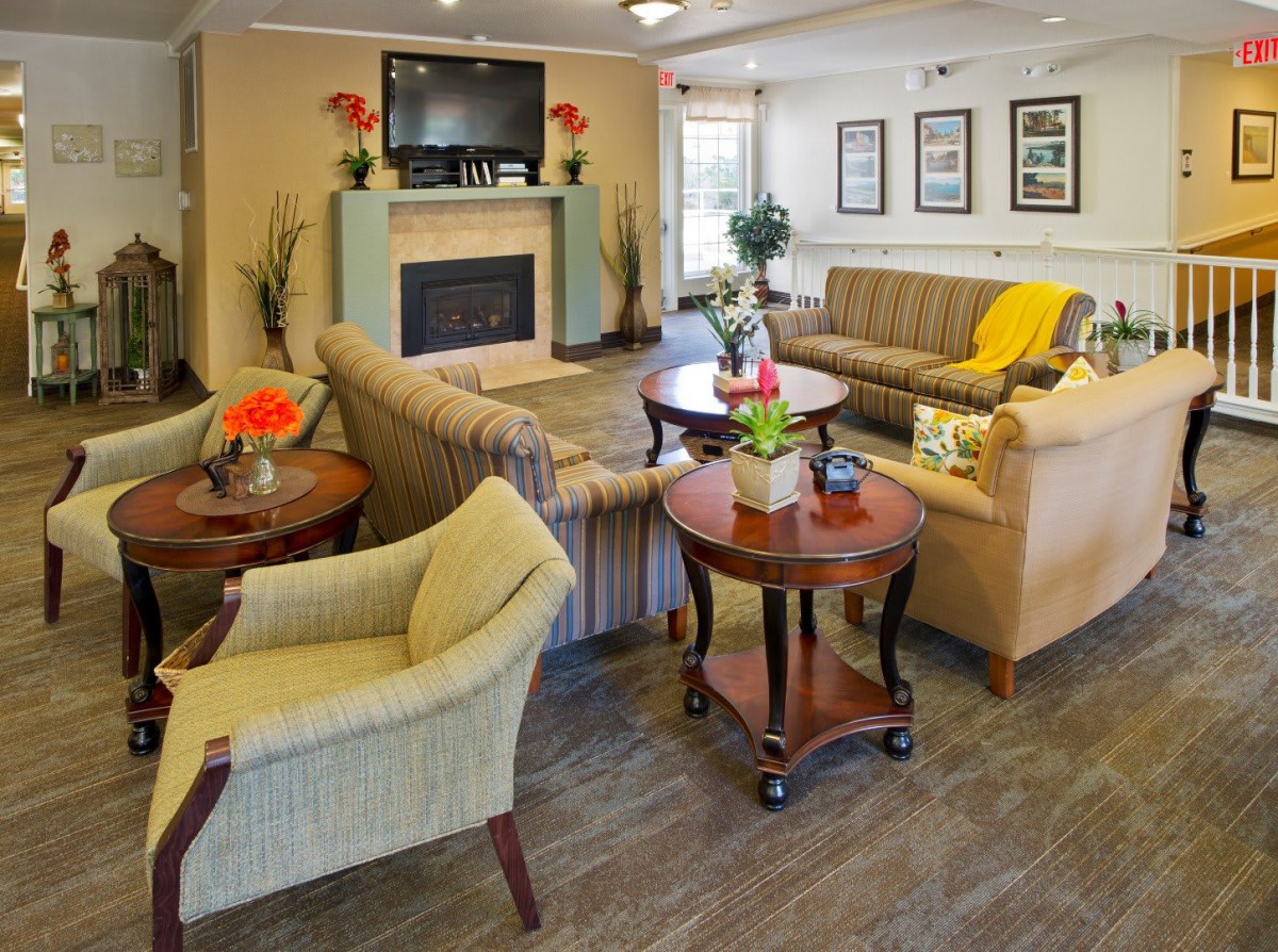 A comfortable and well-decorated living room with sofas, chairs, coffee tables, and a fireplace.