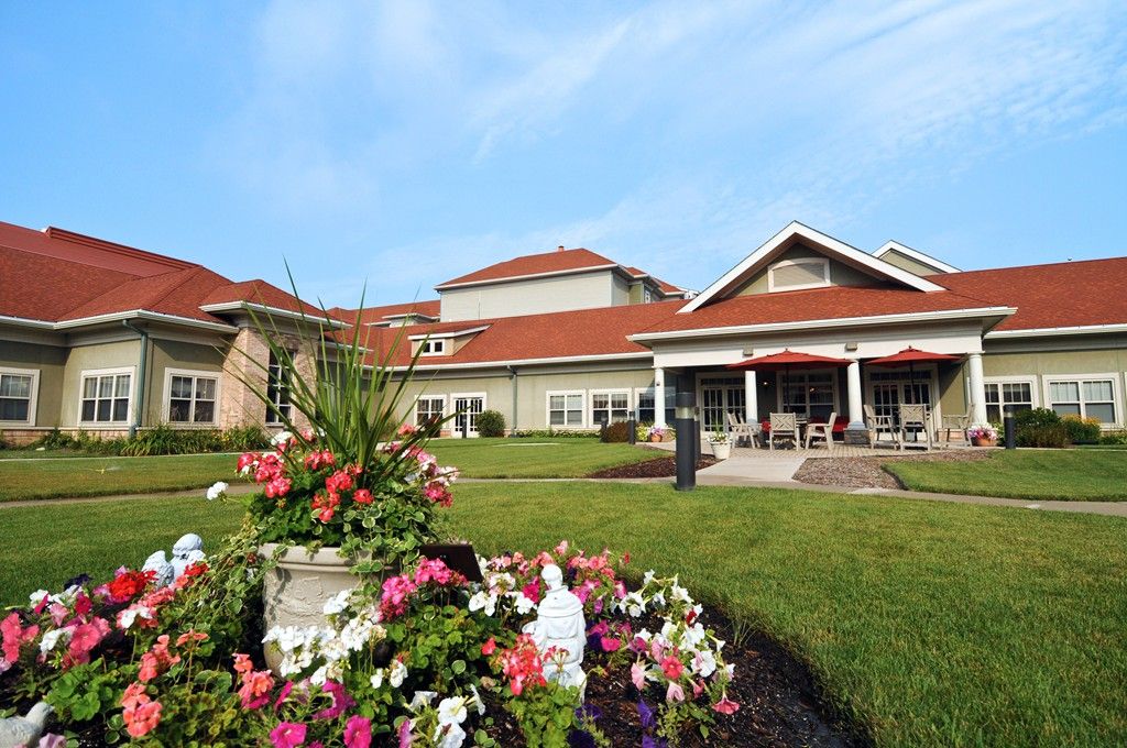 A scenic view of a building with a landscaped garden and colorful flowers.