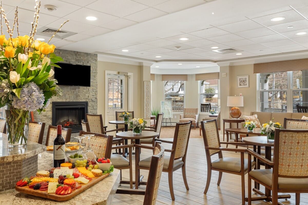 A cozy dining area featuring tables, chairs, and a fireplace.