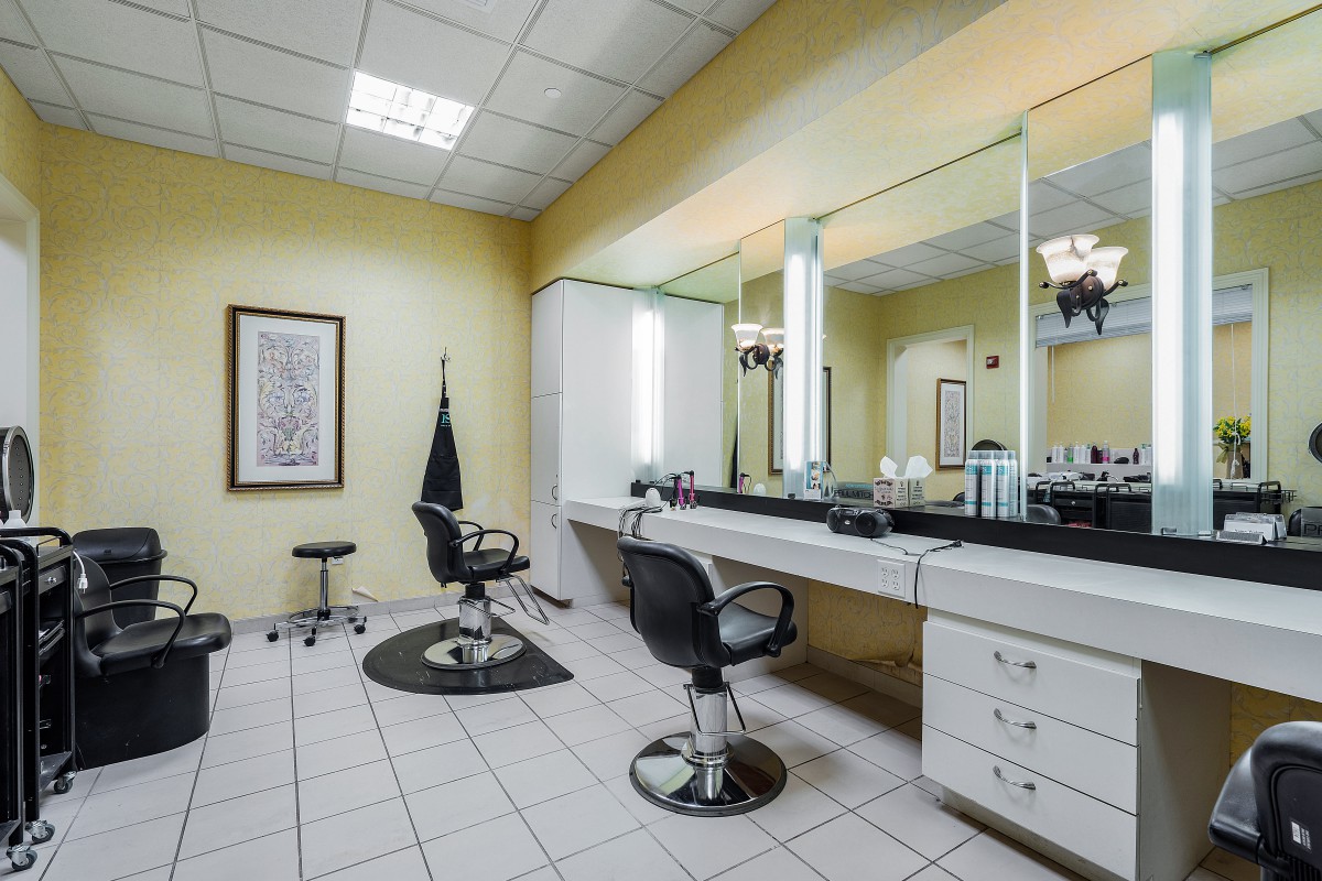 A clean and modern hair salon with styling chairs and large mirrors.