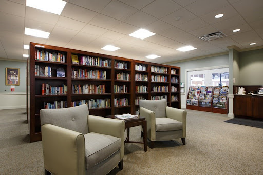 A cozy reading area in a library with comfortable chairs and well-stocked bookshelves.