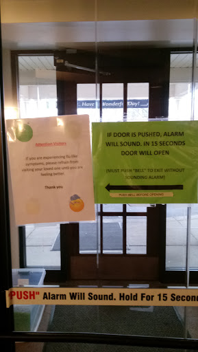 Signs posted on the entrance of a building, providing information to visitors.