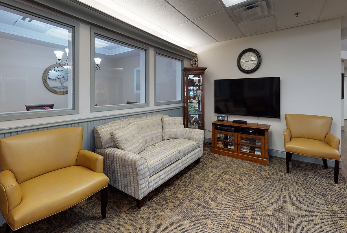 A cozy waiting room with comfortable seating and a television.