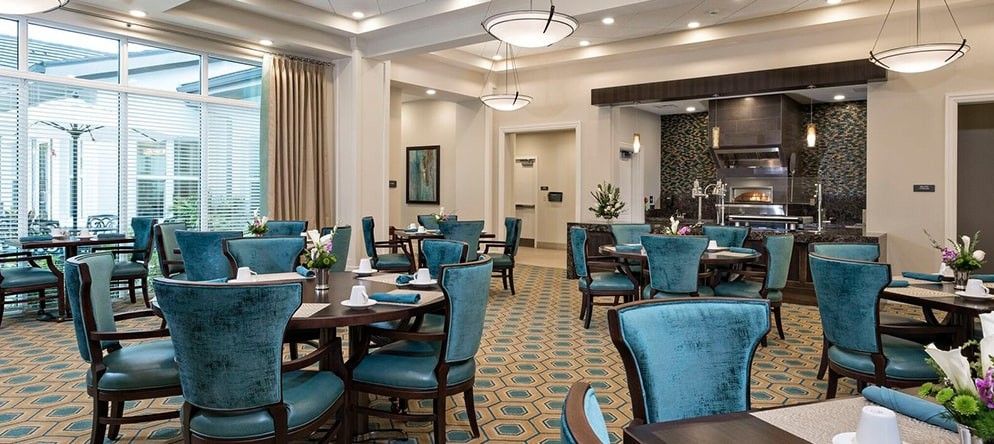 An elegant restaurant interior with blue upholstered chairs and neatly set tables, creating a sophisticated dining atmosphere.