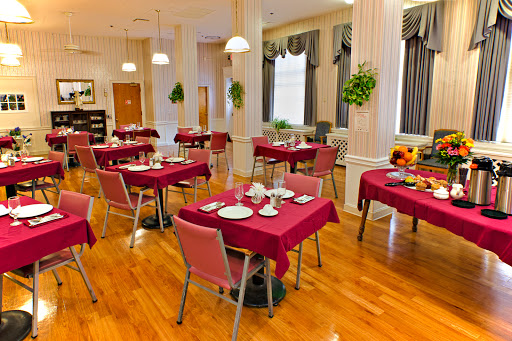 A well-arranged dining area featuring tables with red tablecloths, ready for guests.
