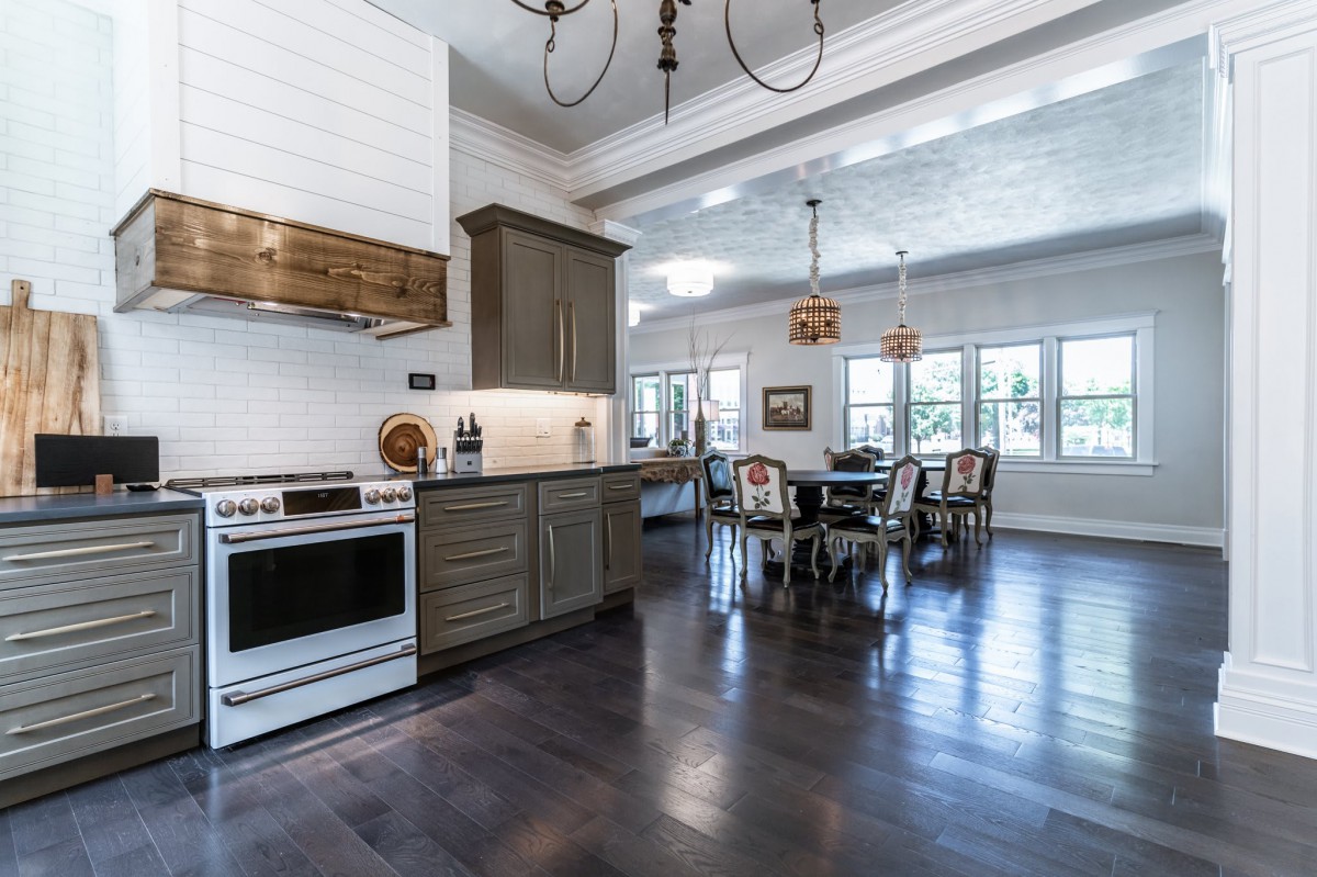 A modern kitchen and dining area featuring dark wood floors and elegant cabinetry.