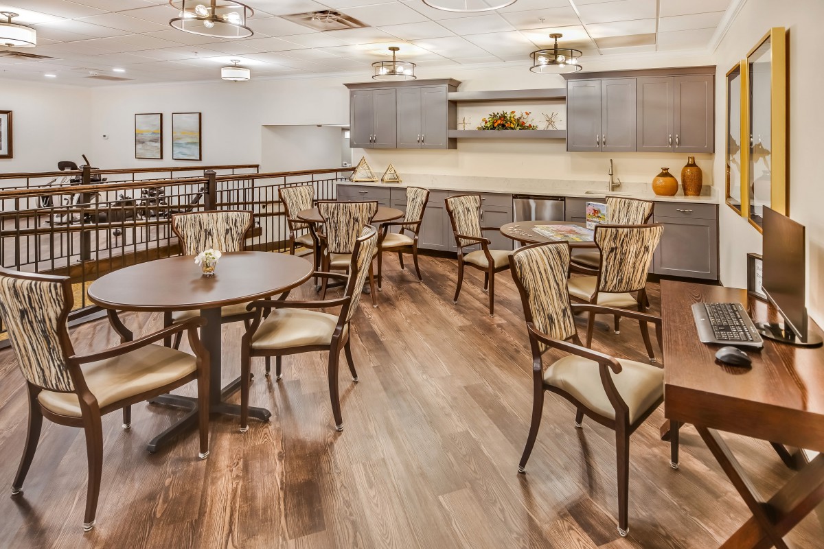 A stylish dining area with wooden floors and elegant tables and chairs.