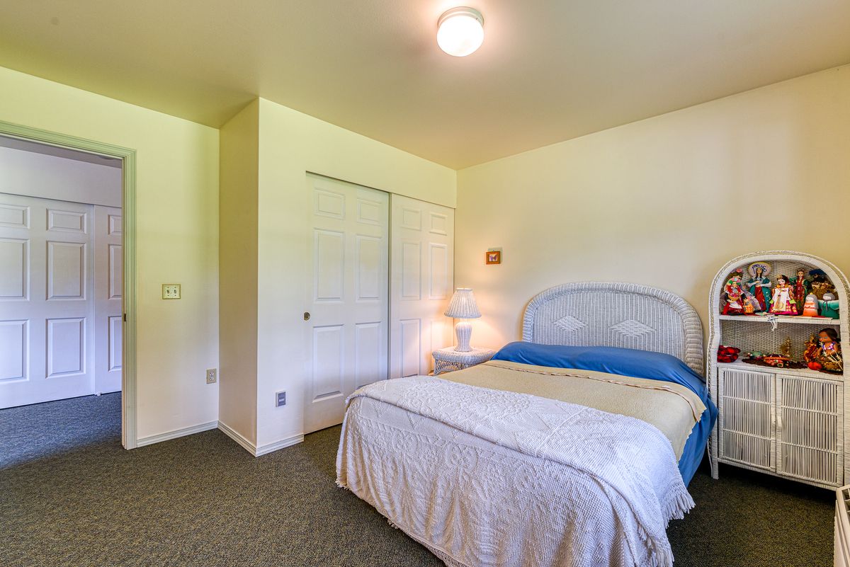 A cozy and minimalist bedroom with a bed, lamp, and closet.