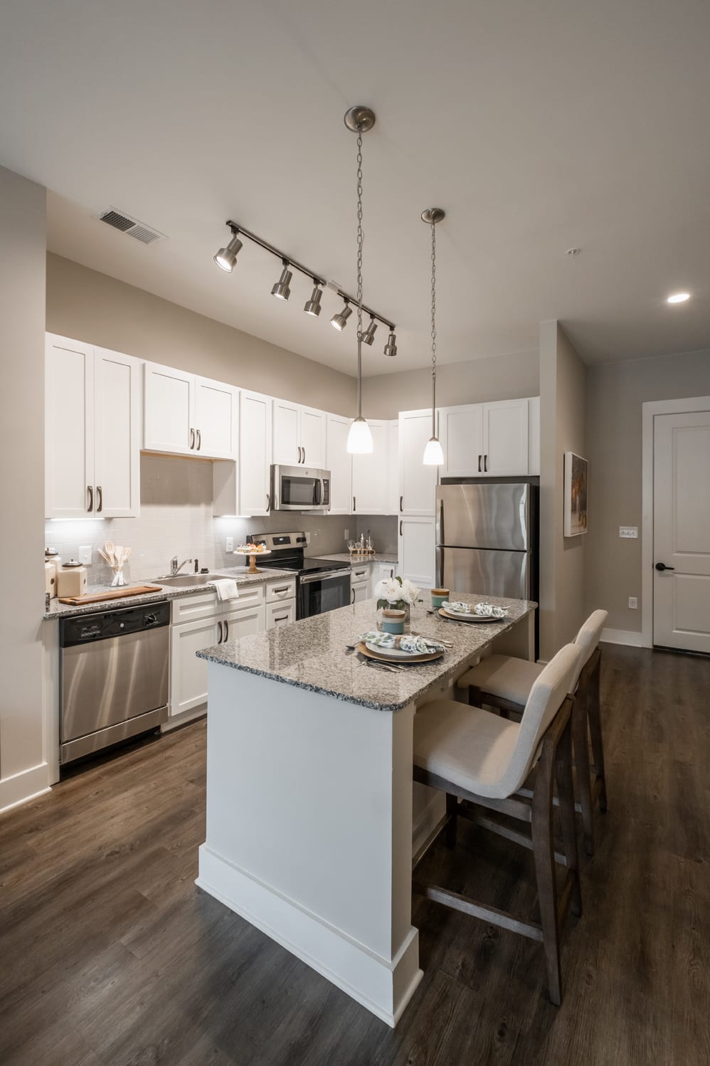 A modern kitchen with sleek design, featuring an island counter and stainless steel appliances.