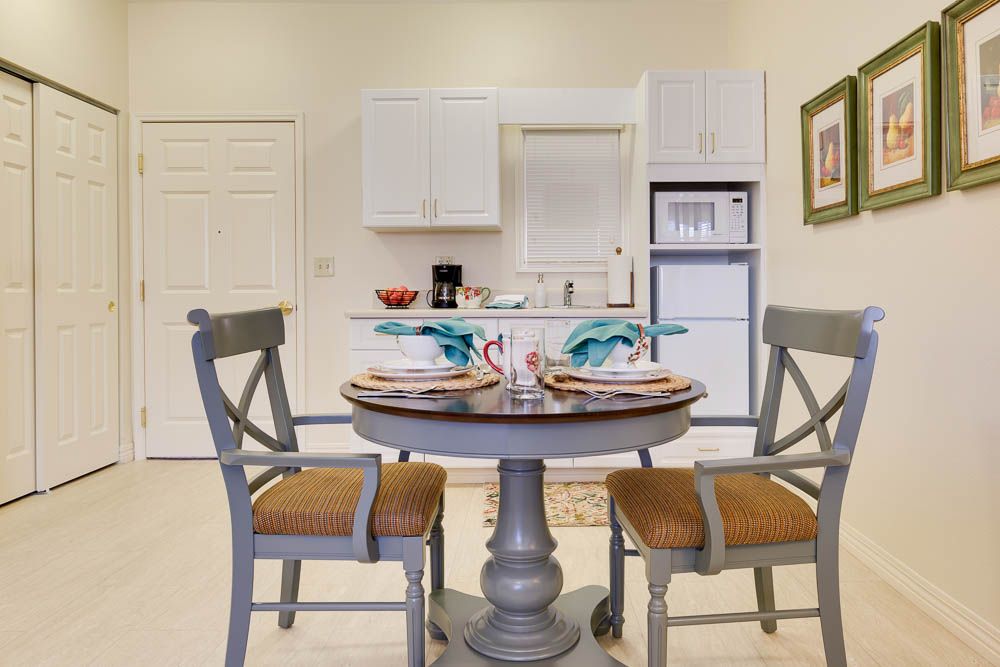 A cozy dining area with a round table set for two, nestled in a compact kitchen space.