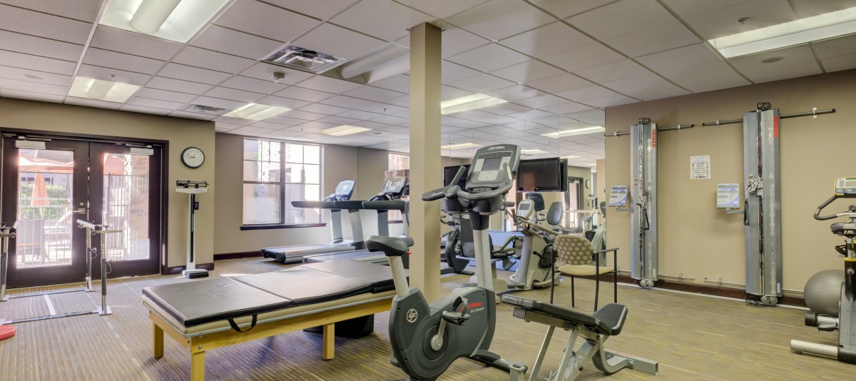 A well-equipped gym with various exercise machines including treadmills and stationary bikes.