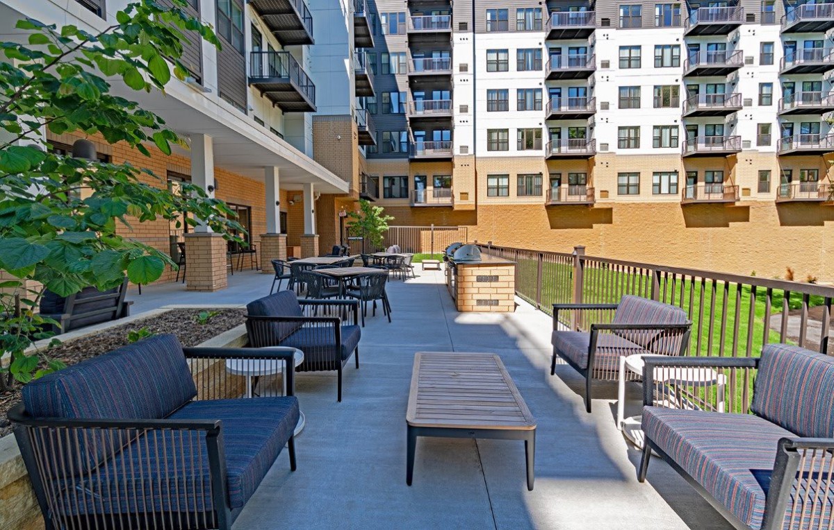 Modern apartment complex with outdoor seating area.