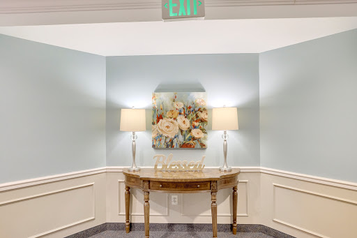 A cozy corner featuring a decorative table with floral artwork and soft lighting.