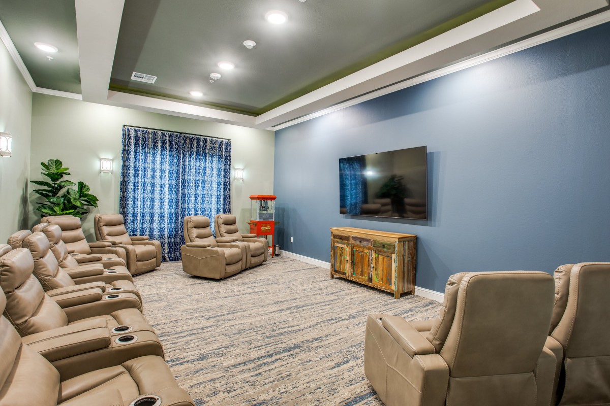 A modern home theater with recliner seating and a large TV screen.