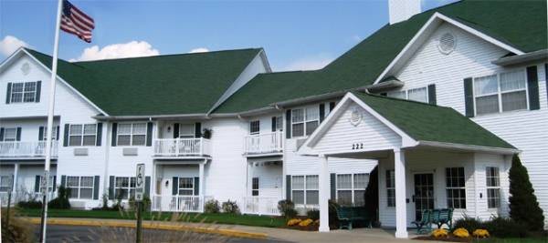 A residential building with a green roof and white exterior.