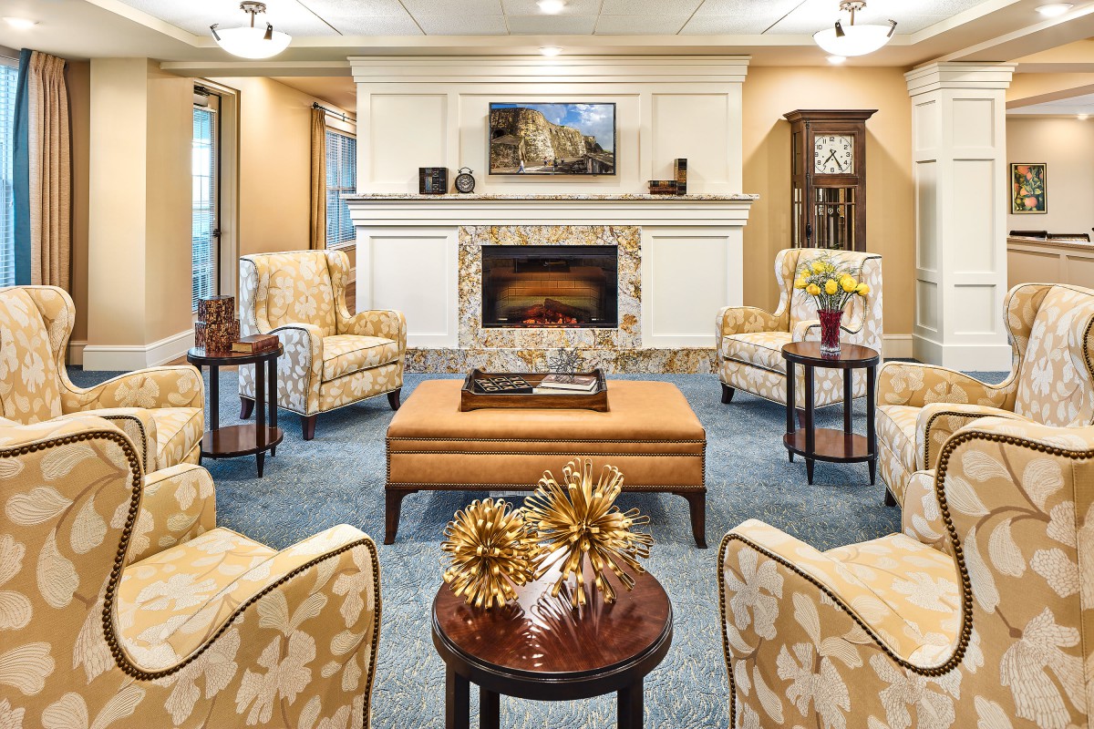 A cozy living room with elegant furniture and a central fireplace.