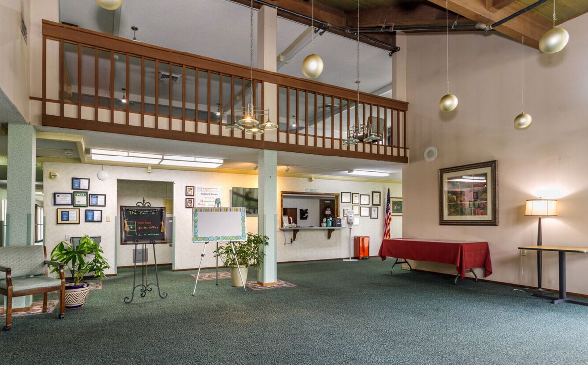 A spacious lobby with a balcony, reception desk, and comfortable seating.