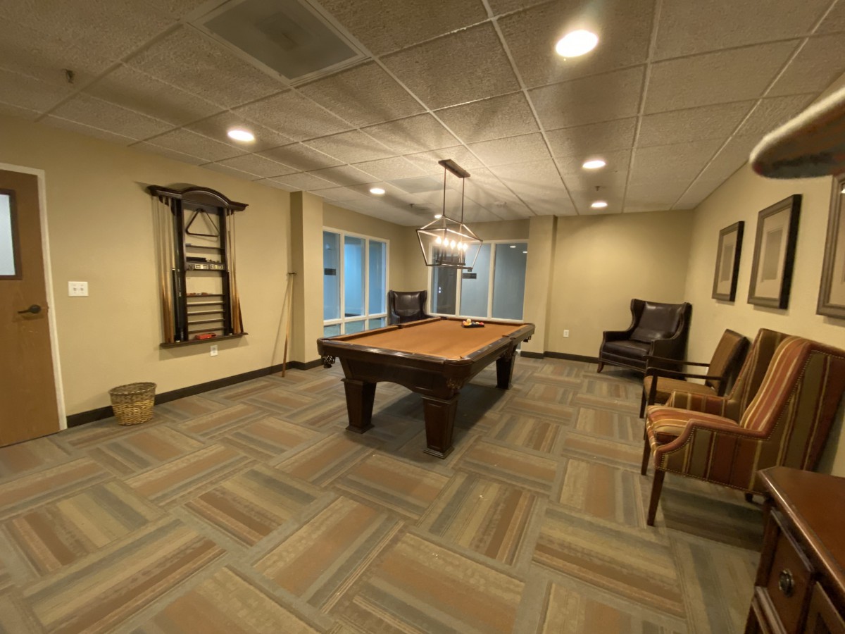 A cozy recreation room featuring a pool table and comfortable seating.