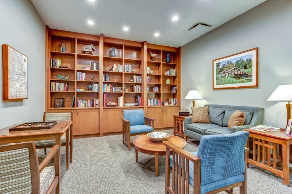 A cozy library corner with wooden bookshelves and comfortable seating.