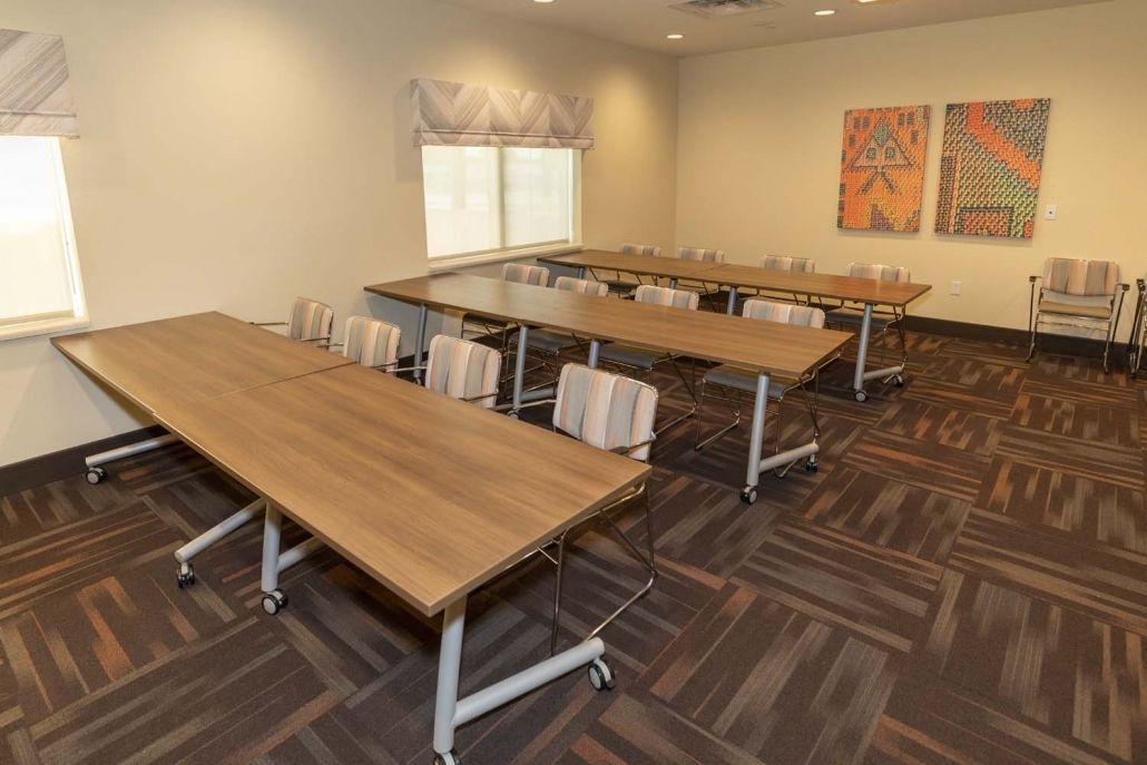 An empty conference room with arranged tables and chairs.