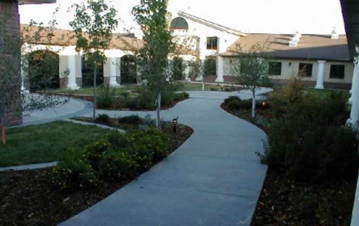 A landscaped garden with a winding pathway leading to a building.