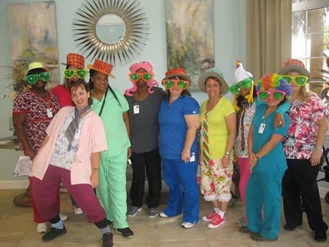A group of people dressed in colorful outfits and hats, enjoying a fun indoor gathering.