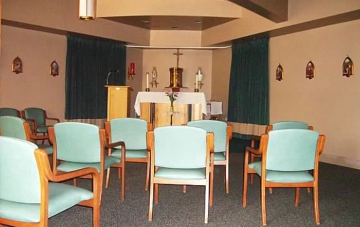 A small chapel interior with chairs arranged facing the altar.