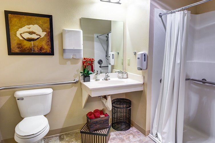 A modern bathroom featuring a sink with a mirror, a shower area, and decorative elements.