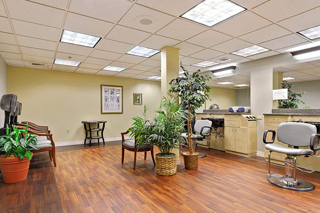 A spacious waiting room with seating, potted plants, and a reception desk.