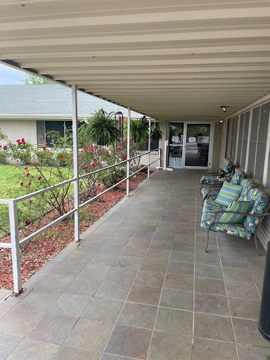 A cozy porch area with seating, surrounded by a garden.