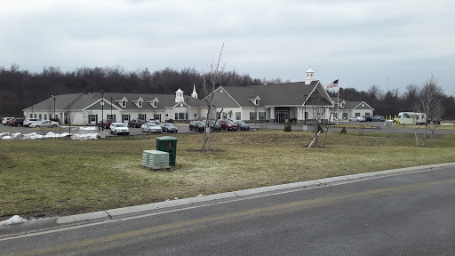 A view of a residential building with landscaped grounds and parked cars.