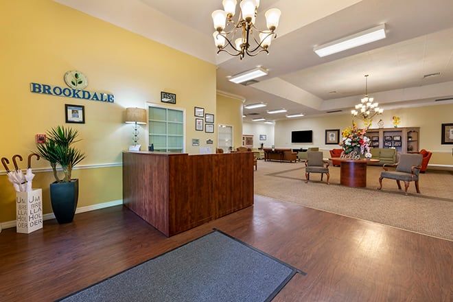 A welcoming reception area with a wooden desk and chandeliers in an inviting lobby.